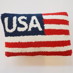 an american flag hooked up to a pillow with the word usa written on it in red, white and blue