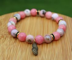 Handcrafted Australian Opal and Rhodochrosite Beaded Bracelet with Peanut Charm Show your love for everyone's favorite spy daughter with this handmade bracelet themed around her! With her pink, black, and gold color scheme and a nod to her favorite snack, this bracelet is a great way to add a little bit of anime flare to any outfit. This would make a great gift for any fan of the show or manga! The bracelet is made from 8mm genuine Australian opal and rhodochrosite with a peanut charm. It is str Pink Spiritual Charm Bracelet For Friendship, Handmade Pink Spiritual Charm Bracelet, Peanuts Charm, Spy Girl, Gold Color Scheme, Favorite Snack, Australian Opal, Handmade Bracelet, Anime Inspired