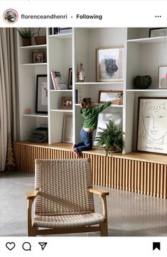 a young child climbing up the side of a book shelf in a living room with bookshelves