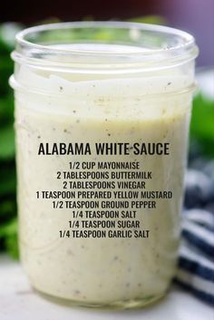 a jar filled with white sauce sitting on top of a table