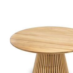 a round wooden table sitting on top of a white floor