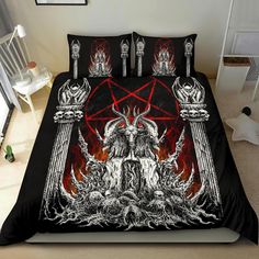 a bed covered in black and red bedspread with an image of a demon on it