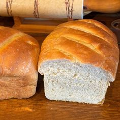 two loaves of bread sitting on top of a wooden table