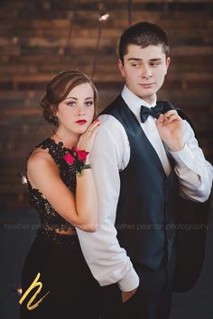 a man in a tuxedo standing next to a woman wearing a black dress