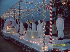 a group of people standing on top of a boat covered in snow and christmas lights