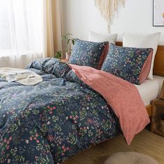 a bed with blue and pink comforters in a bedroom next to a wooden table