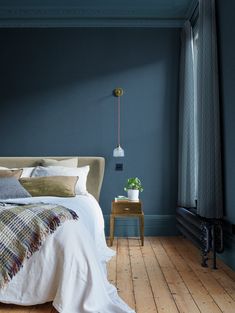 a bedroom with blue walls and wooden floors