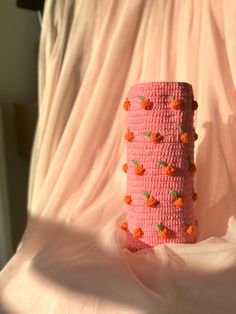 a crocheted pink tube with orange flowers on it