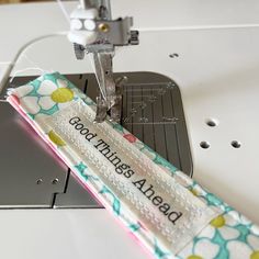 a sewing machine with a piece of fabric next to it that says good things ahead