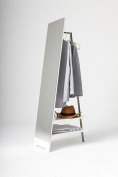 a mirror and shelf with clothes on it