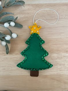 a felt christmas tree ornament on a wooden table