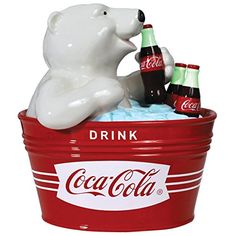 a polar bear sitting on top of a bucket filled with coca - cola bottles and ice