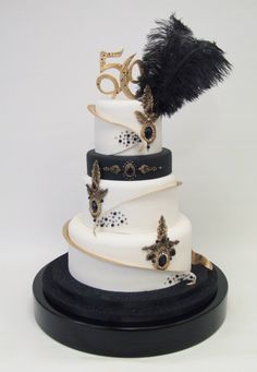 a white and black wedding cake with feathers on top