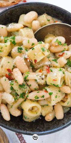 pasta with white beans and parsley in a black bowl