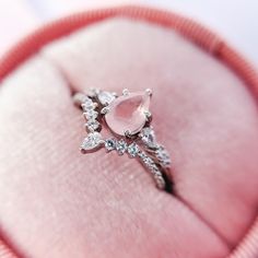 an engagement ring in a pink box with diamonds on the side and inside it,