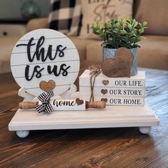 this is us sign and wine corks on a tray with a potted plant