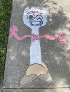 a sidewalk with a painted image of a cartoon character on the ground and pink ribbon around it