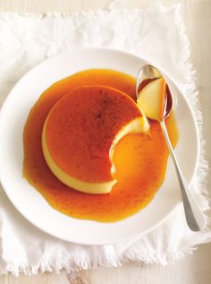 a white plate topped with pancakes covered in orange sauce