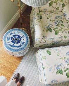 a chair and footstool sitting next to a lamp