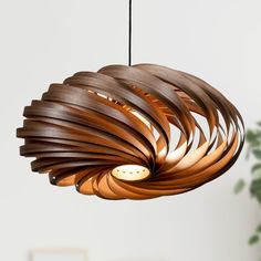 a wooden light fixture hanging from a ceiling in a room with a potted plant