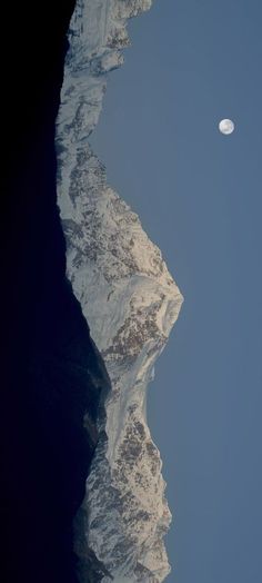 the moon shines brightly above an icy mountain