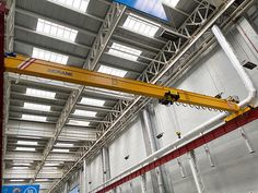 an overhead crane in a warehouse with lots of windows