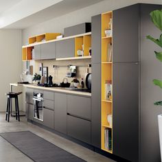 a kitchen with grey cabinets and yellow shelves