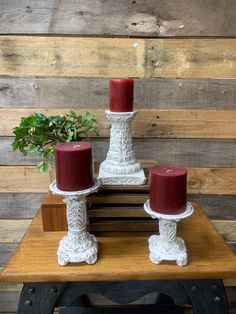 two red candles sitting on top of a wooden table