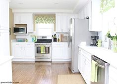 a kitchen with white cabinets and stainless steel appliances