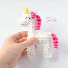 a crocheted unicorn is being held up by someone's hand with the word free pattern on it