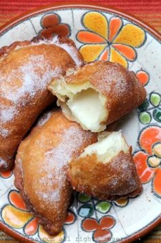 three pastries on a plate with powdered sugar