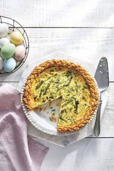 an egg tart sitting on top of a white plate next to eggs and a knife