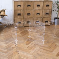 several clear acrylic drawers in a room with wooden flooring and wood furniture