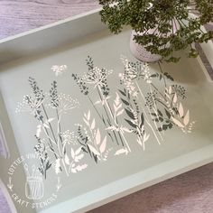 a tray with some flowers on it and a potted plant in the corner next to it