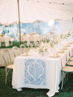 an outdoor tent set up for a wedding reception with tables and chairs covered in white tablecloths