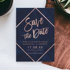 save the date card on top of a wooden table next to some plates and cups