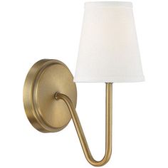 a wall light with a white shade on the side and a gold finish to it