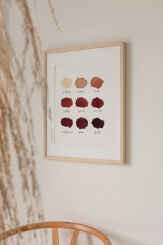 a wooden chair sitting in front of a white wall with different shades of paint on it