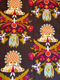 an intricately designed table cloth with birds and flowers on brown background, in various colors