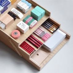 a wooden box filled with lots of different types of pencils and eraser pens