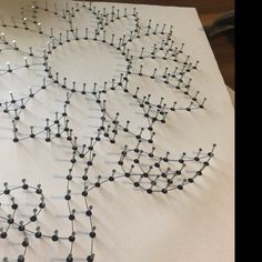 a table topped with lots of black and white dots on top of paper covered in wire