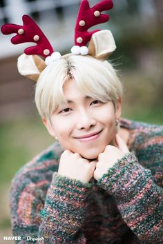 a woman with blonde hair and reindeer antlers on her head smiles at the camera