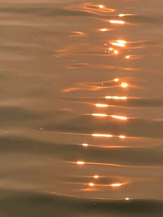 the sun is shining down on the water with ripples in it's wake