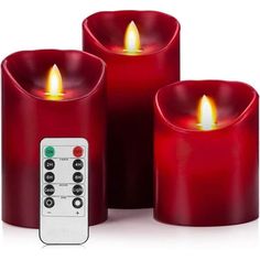 three red candles with remote controls in front of them