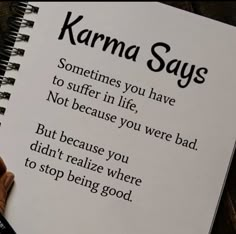 someone is writing on a notebook with the words karma says