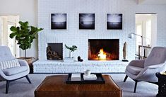 a living room filled with furniture and a fire place in the middle of the room