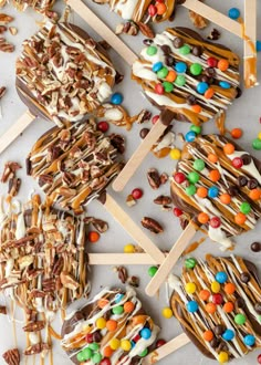 several popsicles with candy and candies on them sitting on top of a table