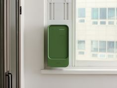 a green box sitting on top of a window sill next to a white wall