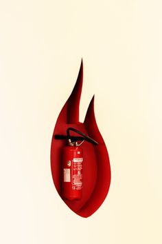 a red fire extinguisher hanging from the side of a wall with scissors