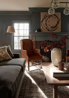 a living room filled with furniture and a fire place in front of a painting on the wall